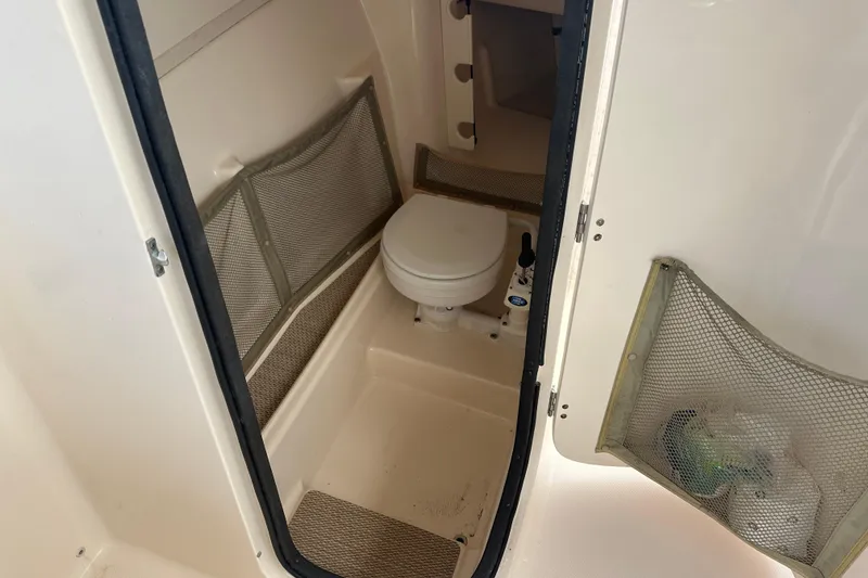 Slide: The Image of 2012 Grady-White Freedom 275 boat interior with compact marine toilet. - 19