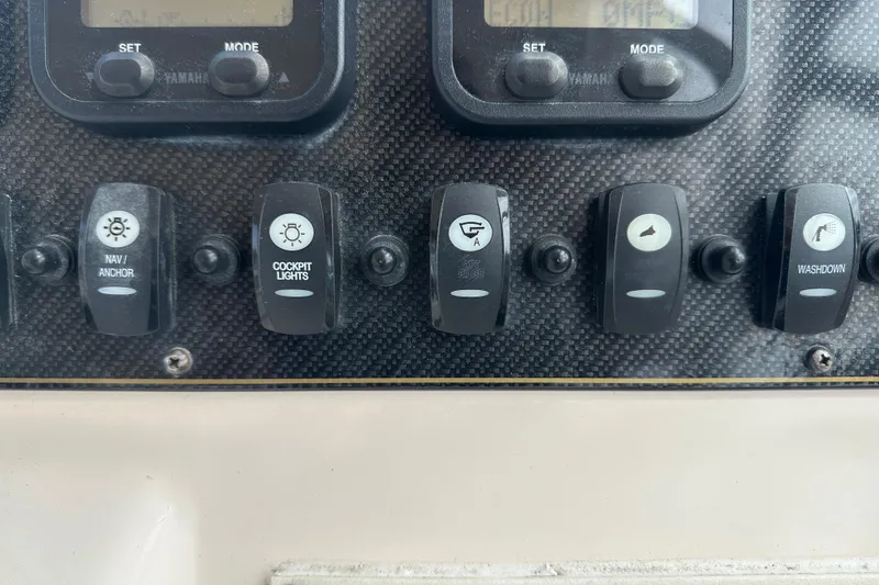 Slide: The Image of Control panel switches on a 2012 Grady-White Freedom 275 boat dashboard. - 23