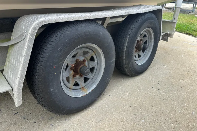 Slide: The Image of Trailer wheels of a 2012 Grady-White Freedom 275 boat on concrete surface. - 4