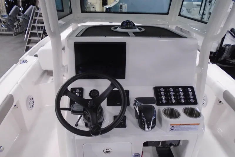 Slide: The Image of 2026 Caymas 24 HB boat dashboard with steering wheel and control panel. - 16