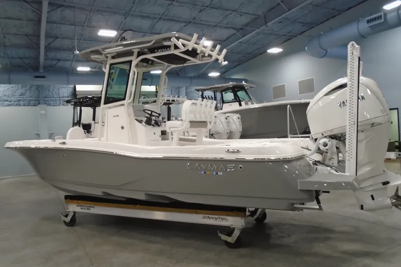 Slide: The Image of 2026 Caymas 24 HB boat displayed indoors, featuring sleek design and modern equipment. - 2