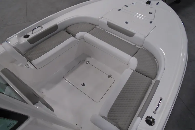 Slide: The Image of 2026 Caymas 24 HB boat interior with cushioned seating and storage compartments. - 23