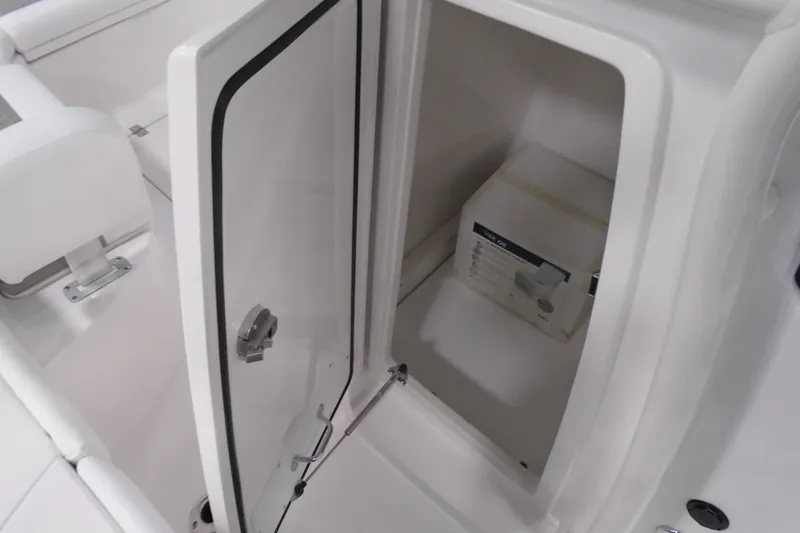 Slide: The Image of 2026 Caymas 24 HB boat storage compartment with open door and interior view. - 28