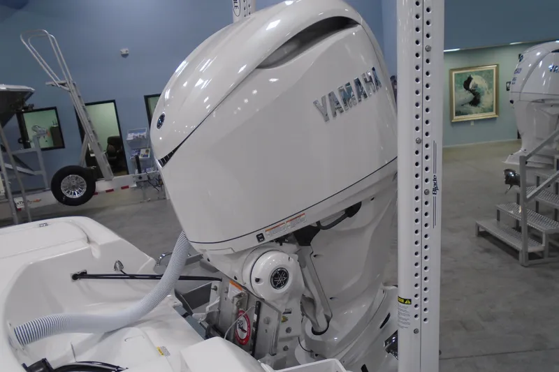 Slide: The Image of 2026 Caymas 24 HB boat with Yamaha outboard motor in showroom. - 8