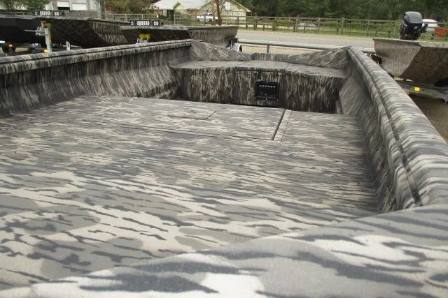 Slide: The Image of 2026 Reaper Boats 653-1690 with camouflage interior design, parked outdoors. - 2