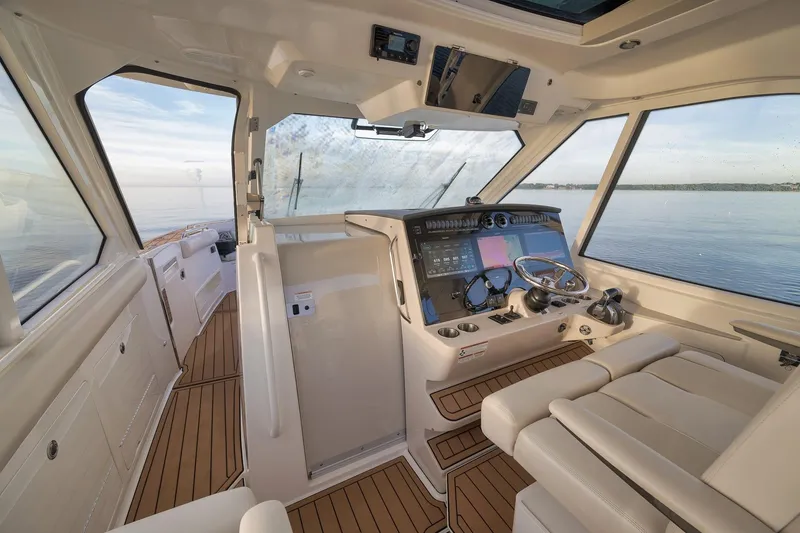 Slide: The Image of Interior of 2020 Boston Whaler 380 Realm boat with modern helm and panoramic windows. - 16
