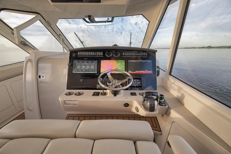 Slide: The Image of 2020 Boston Whaler 380 Realm helm with advanced navigation displays and steering wheel. - 17