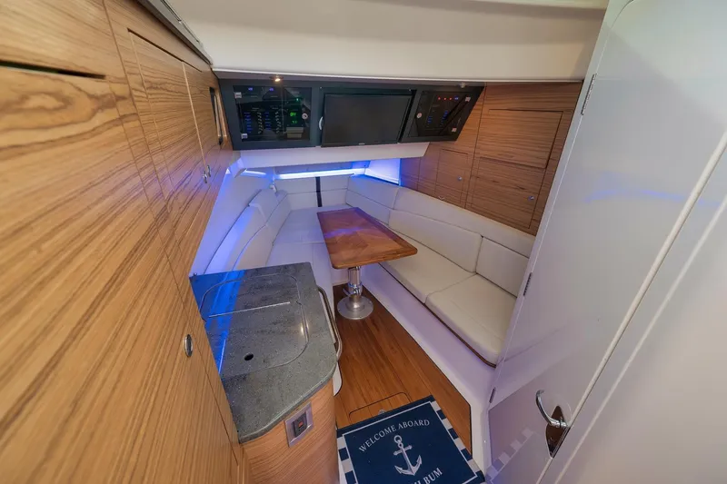 Slide: The Image of 2020 Boston Whaler 380 Realm cabin interior with wood accents and cozy seating area. - 18