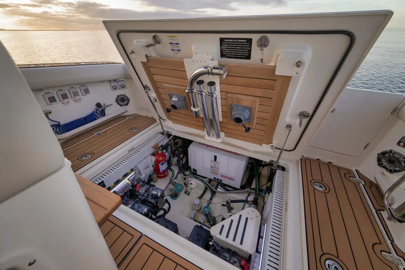 Slide: The Image of 2020 Boston Whaler 380 Realm engine compartment with open hatch, showcasing equipment and storage. - 31