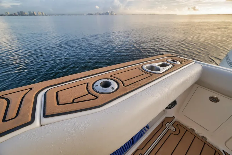 Slide: The Image of 2020 Boston Whaler 380 Realm boat deck with cup holders, overlooking calm water. - 33