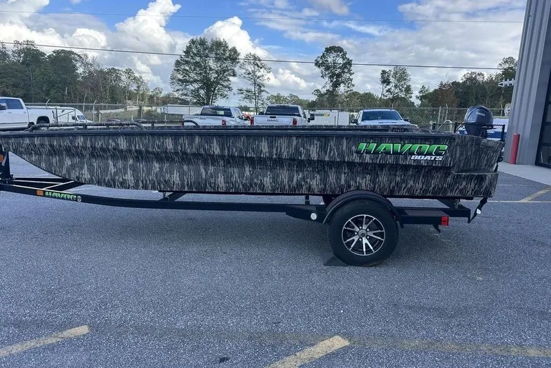 The Image of 2025 Havoc 1860 boat with camouflage design on a trailer, parked outdoors. - 1