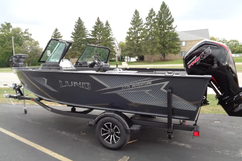 Slide: The Image of 2026 Lund 1775 Adventure Sport boat on trailer, parked outdoors. - 10