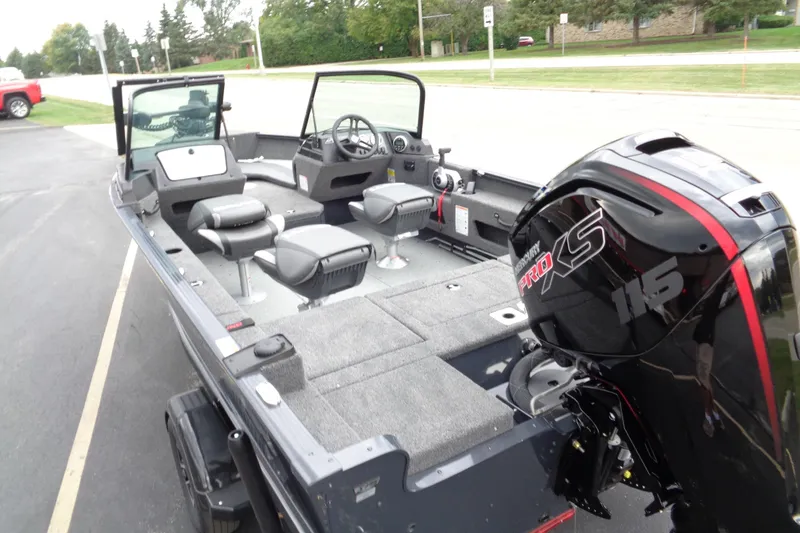 Slide: The Image of 2026 Lund 1775 Adventure Sport boat with Mercury Pro XS 115 engine, parked on pavement. - 11