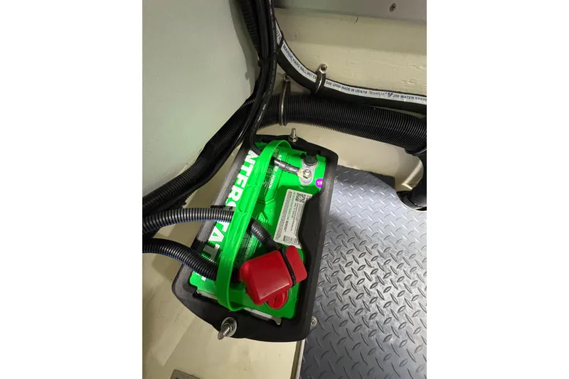 Slide: The Image of Battery compartment in 2023 Formula 400 Super Sport Crossover boat, featuring green battery and wiring. - 43