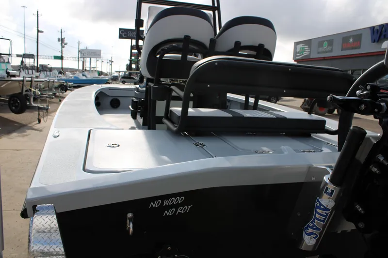 Slide: The Image of 2026 Freedom Boats 23' Warrior console with steering wheel and controls, docked outdoors. - 3
