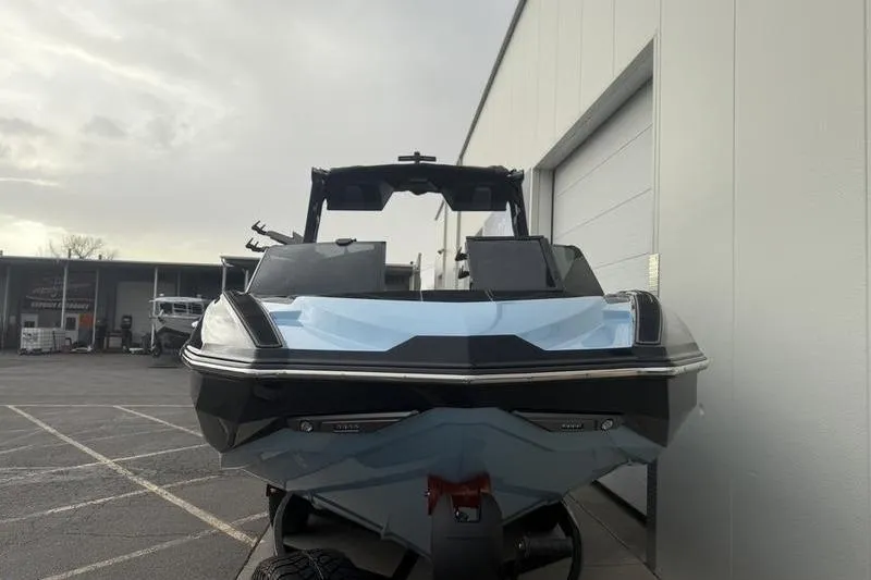 Slide: The Image of 2025 Supra SL 575 boat, sleek design, parked outdoors near a building. - 4