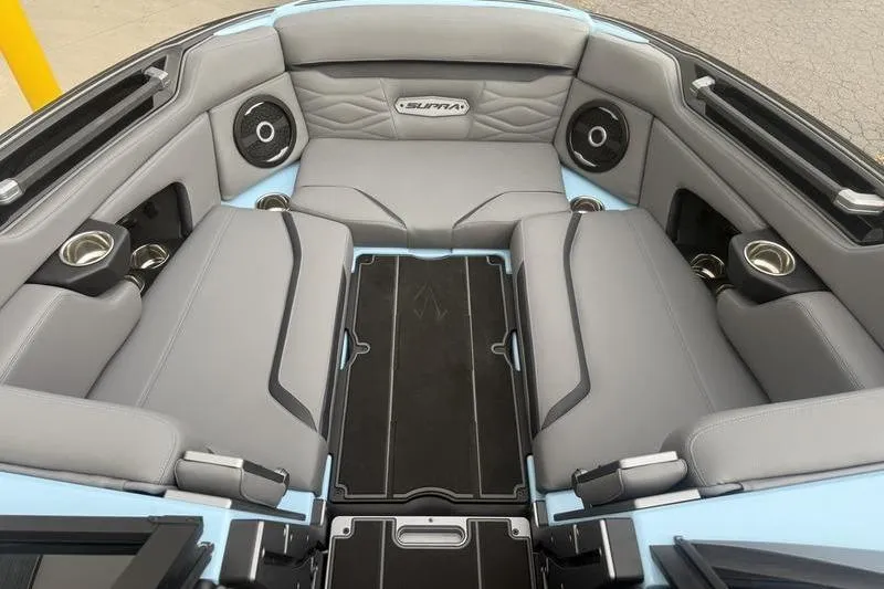 Slide: The Image of 2025 Supra SL 575 boat interior with gray seating, cup holders, and speakers. - 9