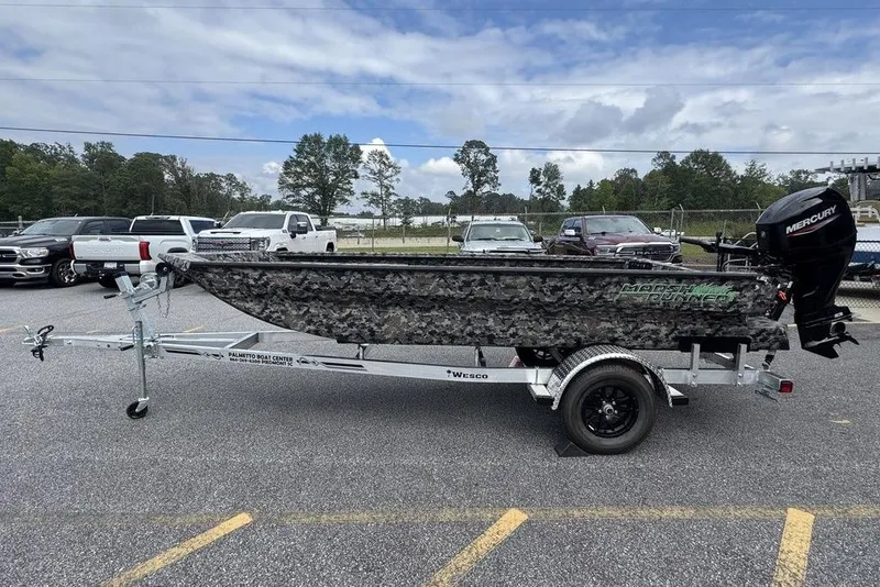 Slide: The Image of 2024 Havoc 1756 boat with camo design on a trailer, parked outdoors. - 11