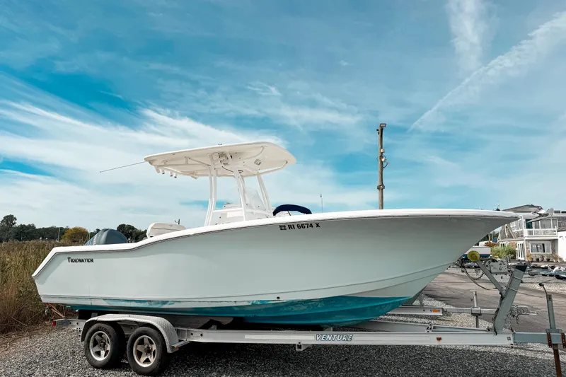 The Image of 2011 Tidewater 230 CC Adventure boat on trailer under clear blue sky. - 0