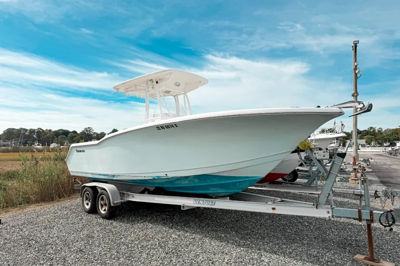 Slide: The Image of 2011 Tidewater 230 CC Adventure boat on trailer under clear blue sky. - 11
