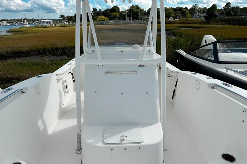 Slide: The Image of Tidewater 230 CC Adventure 2011 boat interior with open deck and scenic marina backdrop. - 8