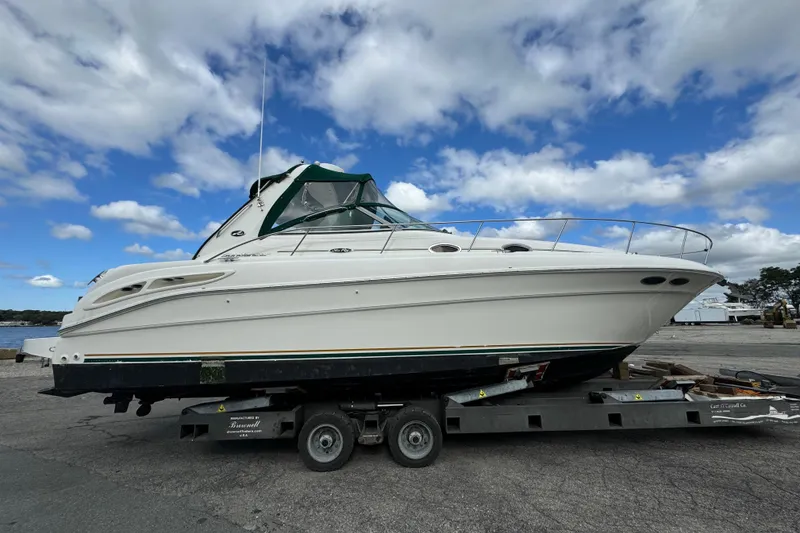 The Image of 2001 Sea Ray 340 Sundancer boat on trailer under blue sky. - 0