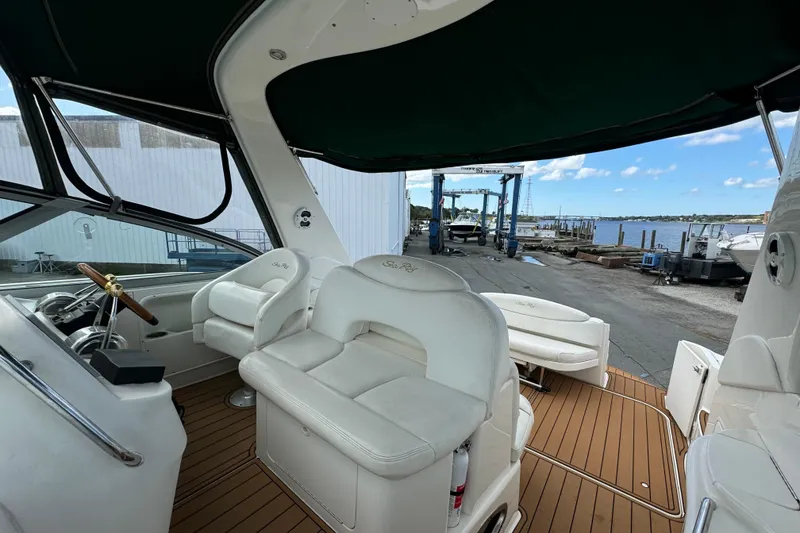 Slide: The Image of 2001 Sea Ray 340 Sundancer boat interior with white seating and wooden deck. - 2