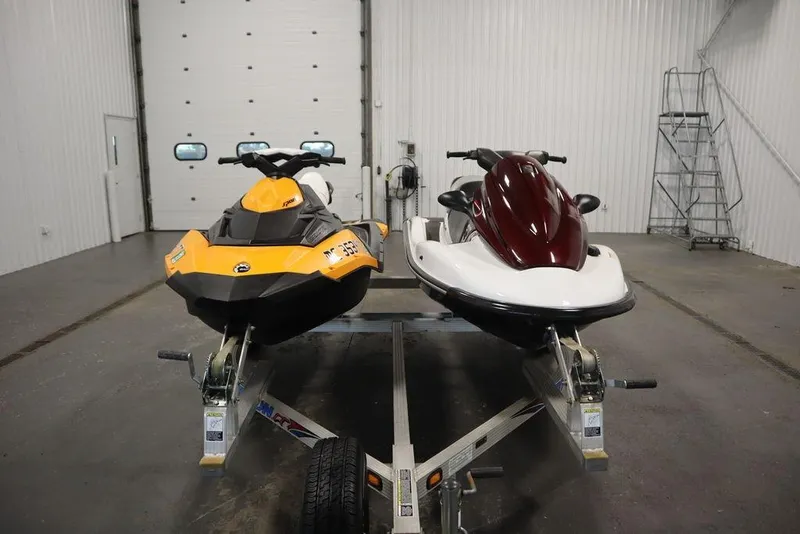 Slide: The Image of Two jet skis, including a 2015 Sea-Doo Spark for 3, on a trailer in a garage. - 3