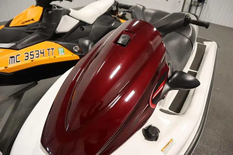 Slide: The Image of 2015 Sea-Doo Spark for 3 jet ski, maroon and white, parked indoors. - 5