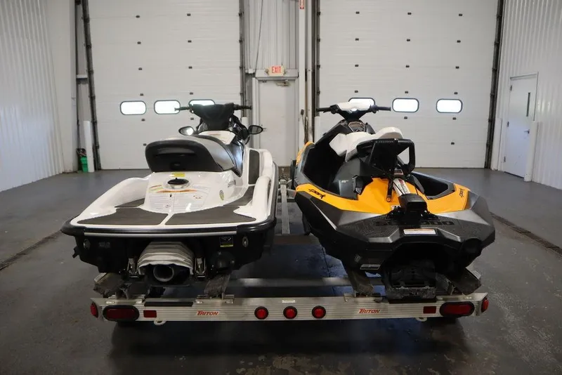 Slide: The Image of Two 2015 Sea-Doo Spark jet skis on a trailer in a garage. - 7