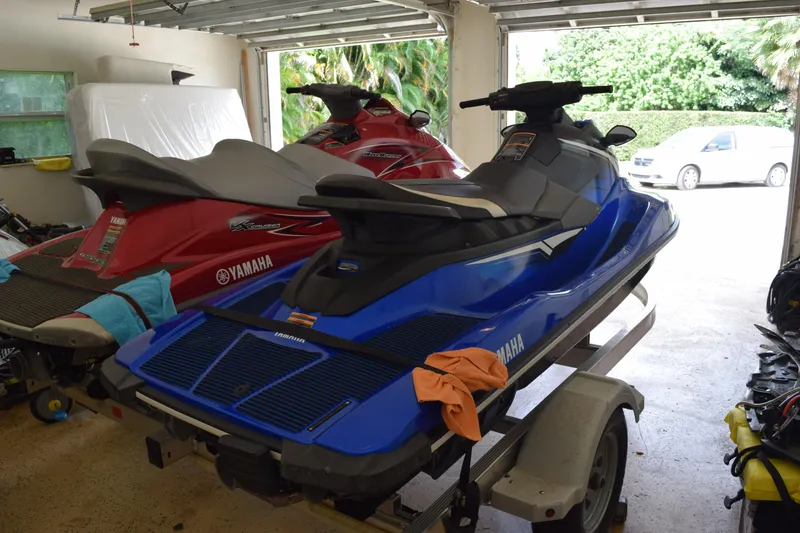 Slide: The Image of 2018 Yamaha WaveRunner EX Deluxe in garage, blue and red models on trailer. - 13