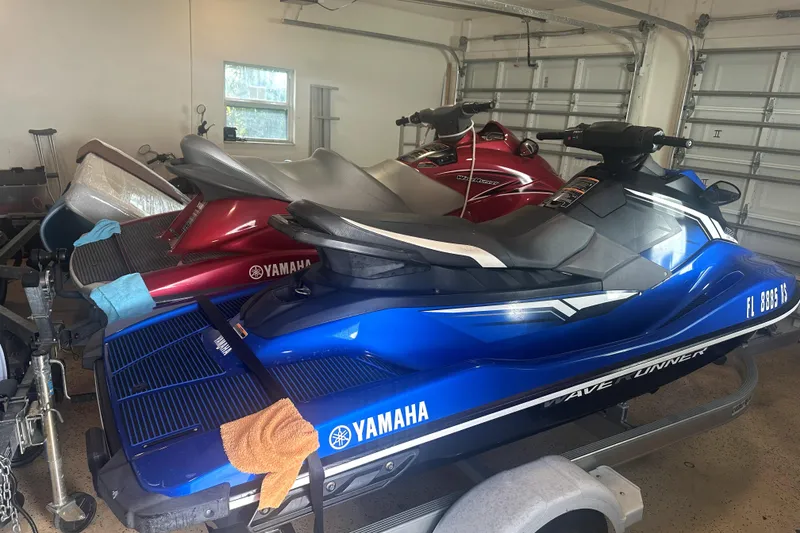 Slide: The Image of 2018 Yamaha WaveRunner EX Deluxe in garage, blue and red models on trailer. - 14