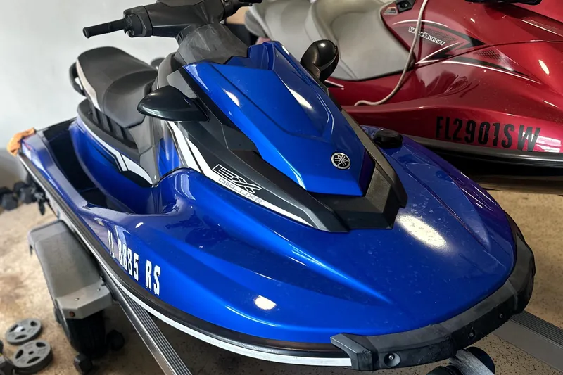 Slide: The Image of 2018 Yamaha WaveRunner EX Deluxe in blue, parked indoors on a trailer. - 2