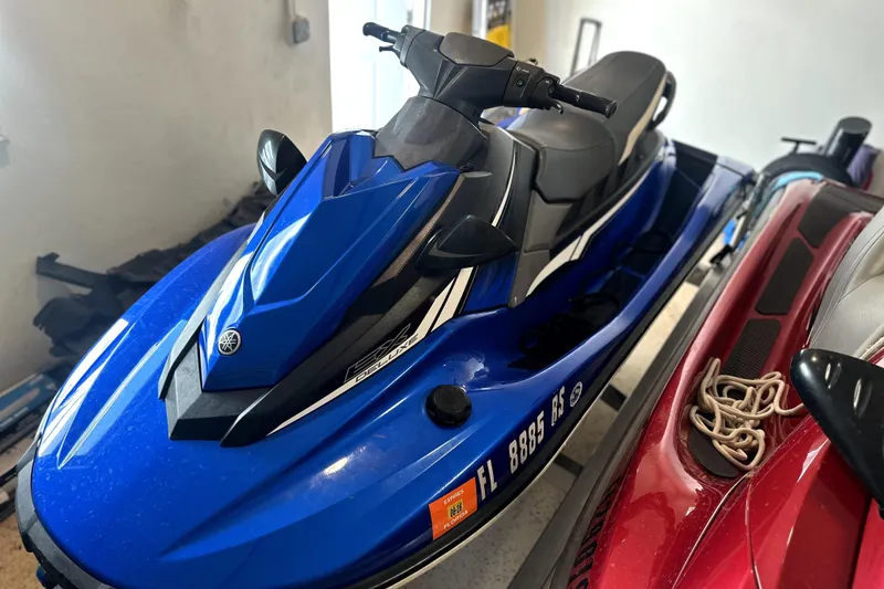 Slide: The Image of 2018 Yamaha WaveRunner EX Deluxe in blue, parked indoors beside another watercraft. - 4