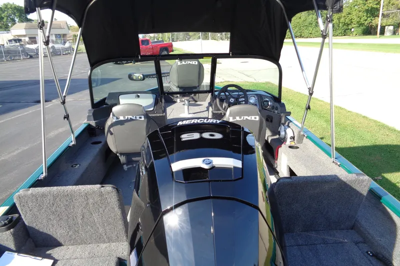 Slide: The Image of 2026 Lund 1675 Adventure Sport boat interior with Mercury 90 engine, canopy, and seating. - 12