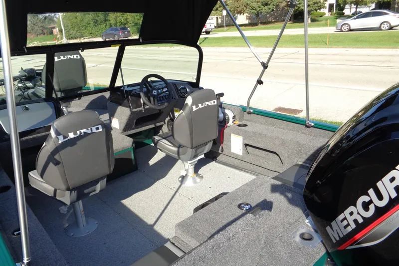 Slide: The Image of 2026 Lund 1675 Adventure Sport boat interior with Mercury engine, featuring comfortable seating and modern controls. - 13