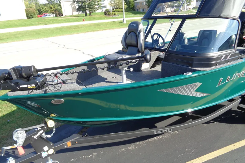 Slide: The Image of 2026 Lund 1675 Adventure Sport boat on trailer, green exterior, parked outdoors. - 4