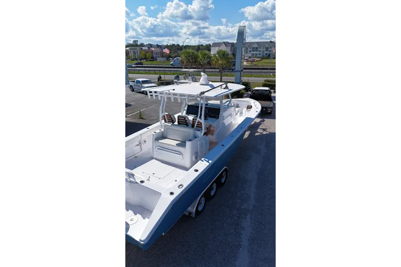 Slide: The Image of 2023 Jupiter 40 boat on trailer, parked outdoors under a partly cloudy sky. - 12