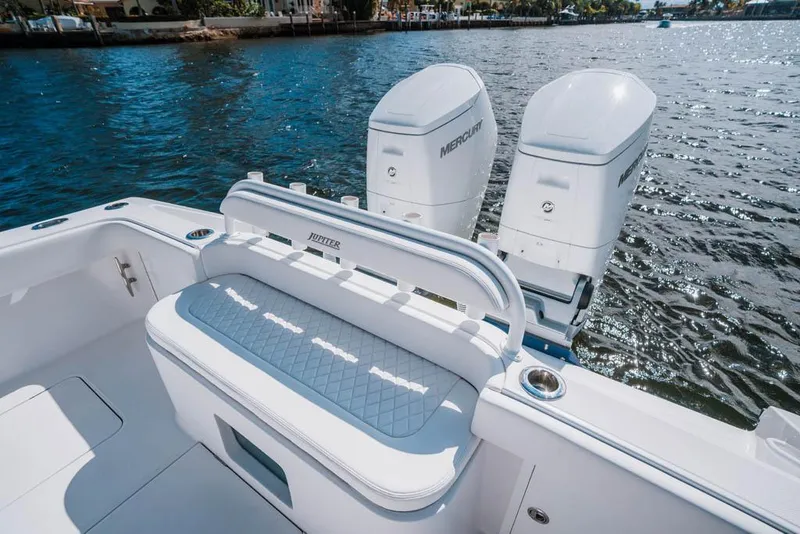 Slide: The Image of 2023 Jupiter 40 boat with spacious seating and sleek design, docked outdoors. - 8