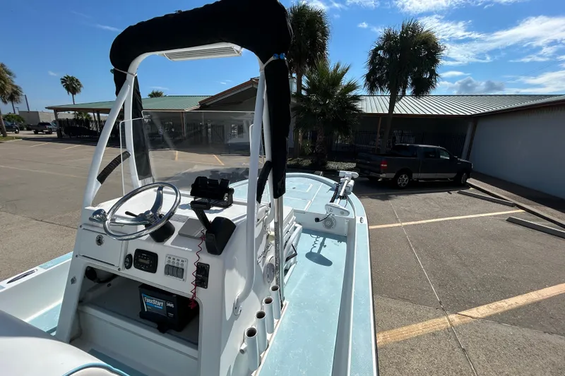 Slide: The Image of 2016 Shallow Sport 21 Sport boat in parking lot, clear sky, palm trees in background. - 10