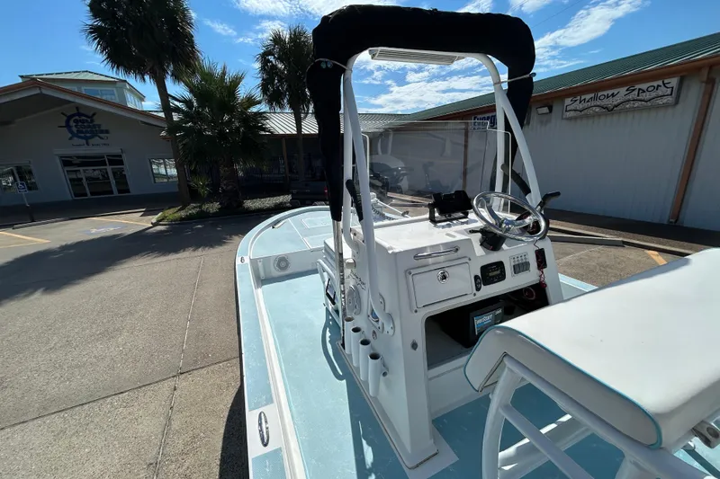 Slide: The Image of 2016 Shallow Sport 21 Sport boat with console, parked near a building under a clear sky. - 11