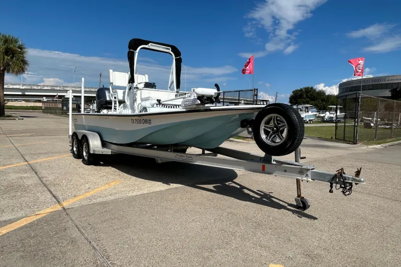 Slide: The Image of 2016 Shallow Sport 21 Sport boat on trailer in parking lot under blue sky. - 4