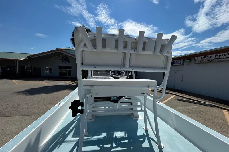 Slide: The Image of 2016 Shallow Sport 21 Sport boat interior with seating and rod holders under a clear sky. - 9