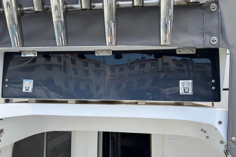 Slide: The Image of 1993 Blackfin Sportfisher boat detail with chrome rod holders and storage compartment. - 11