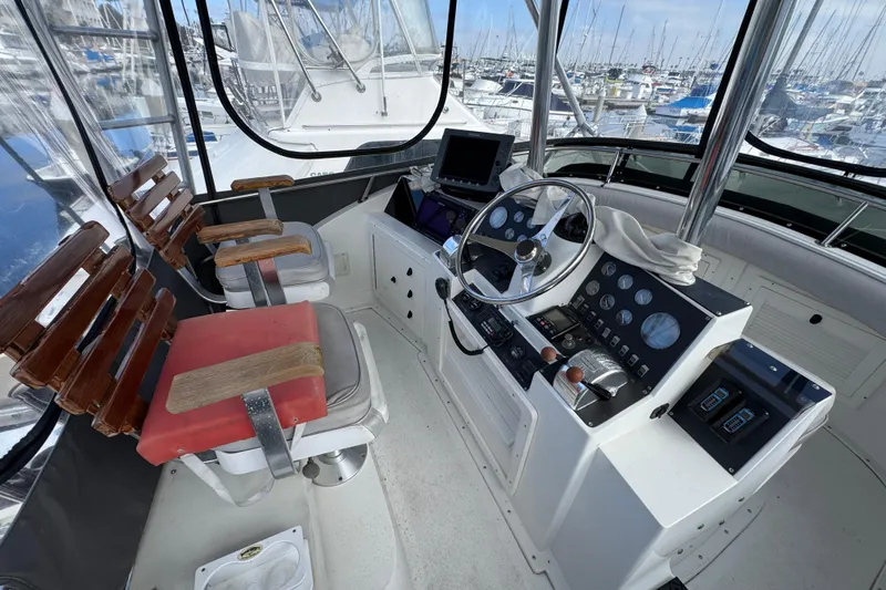Slide: The Image of 1993 Blackfin Sportfisher helm with steering wheel, controls, and seating in a marina setting. - 14