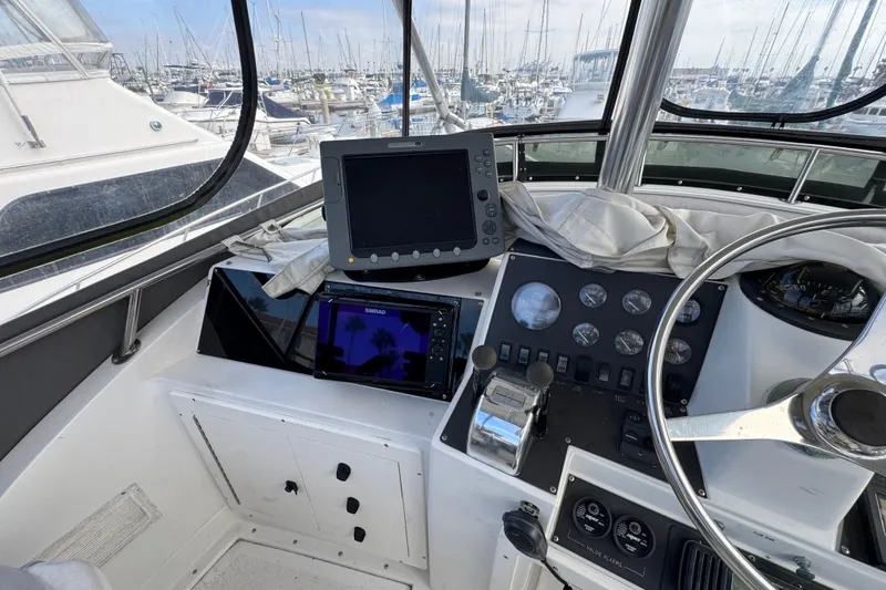 Slide: The Image of 1993 Blackfin Sportfisher helm with navigation equipment and marina view. - 15