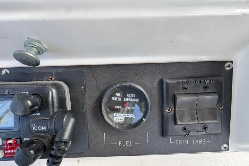 Slide: The Image of 1993 Blackfin Sportfisher dashboard with fuel filter and trim tab controls. - 23