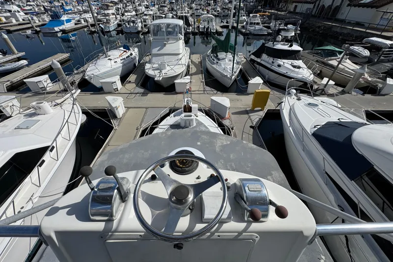 Slide: The Image of 1993 Blackfin Sportfisher boat helm overlooking marina with numerous docked boats. - 29