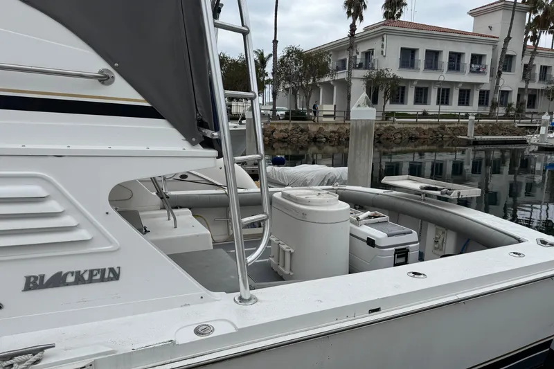 Slide: The Image of 1993 Blackfin Sportfisher boat docked at marina with buildings in background. - 3