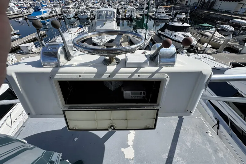 Slide: The Image of 1993 Blackfin Sportfisher helm with steering wheel, controls, and marina view. - 32